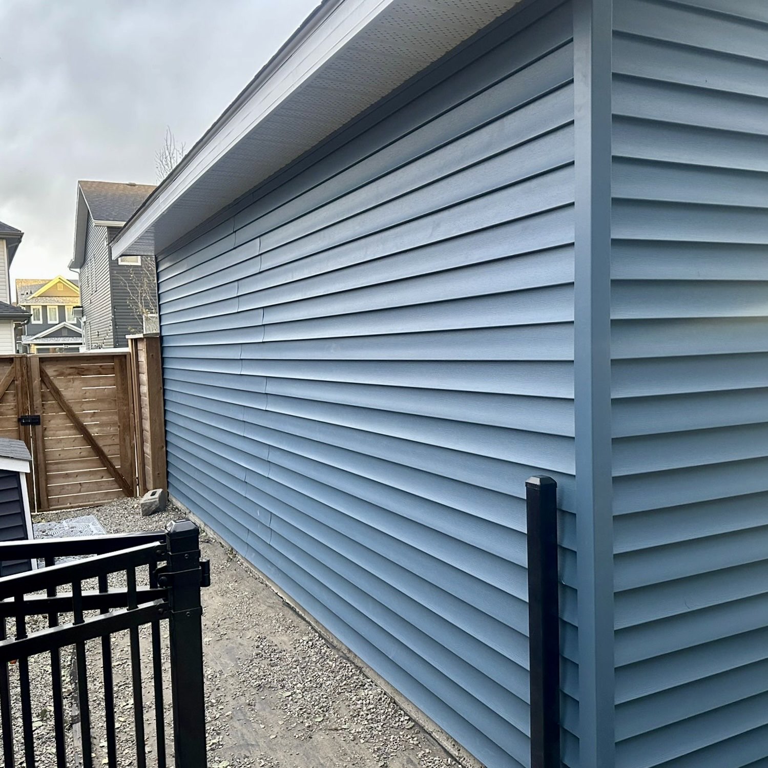 Two-storey garage suite with grey vinyl siding and white soffit/fascia