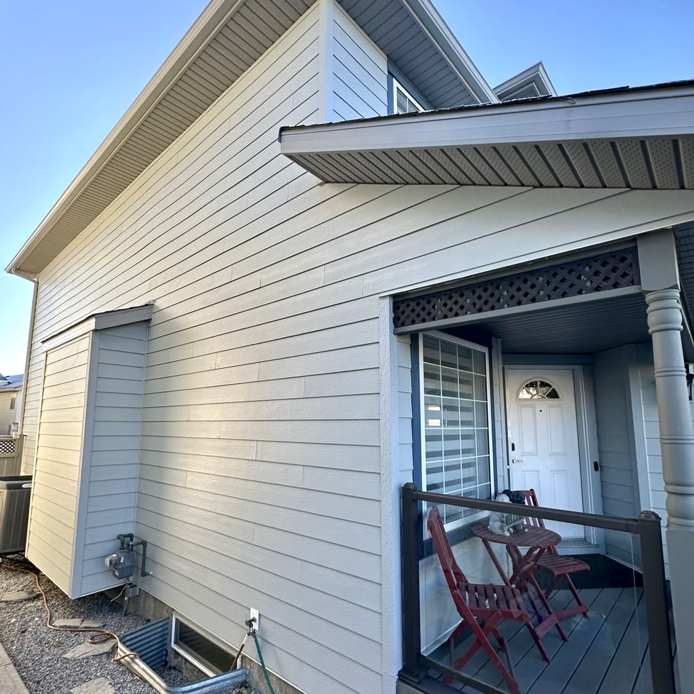 Cream fiber-cement lap siding wrapping a Calgary home corner with covered porch