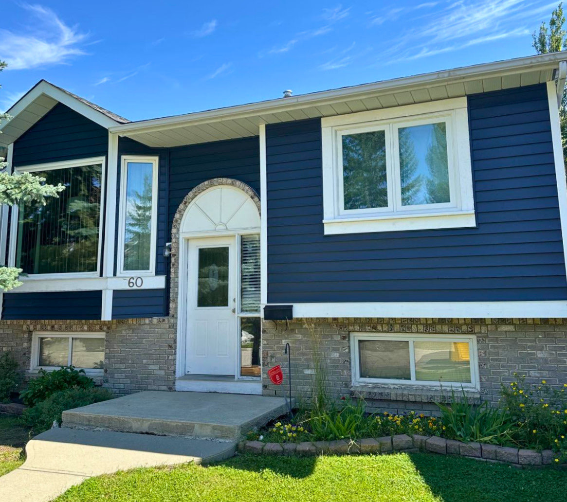 Calgary bi-level home re-sided in dark navy vinyl lap siding with white trim